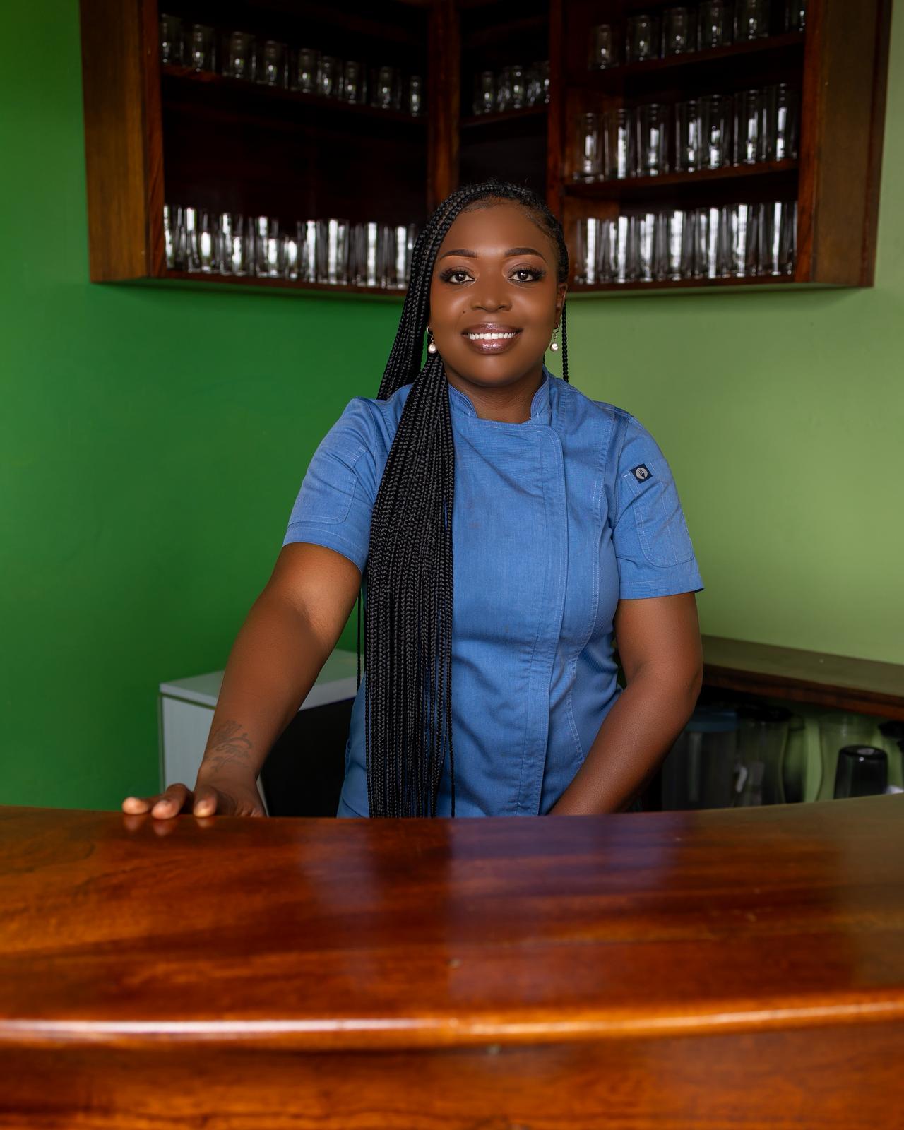 The founder standing behind a counter in her chef's jacket