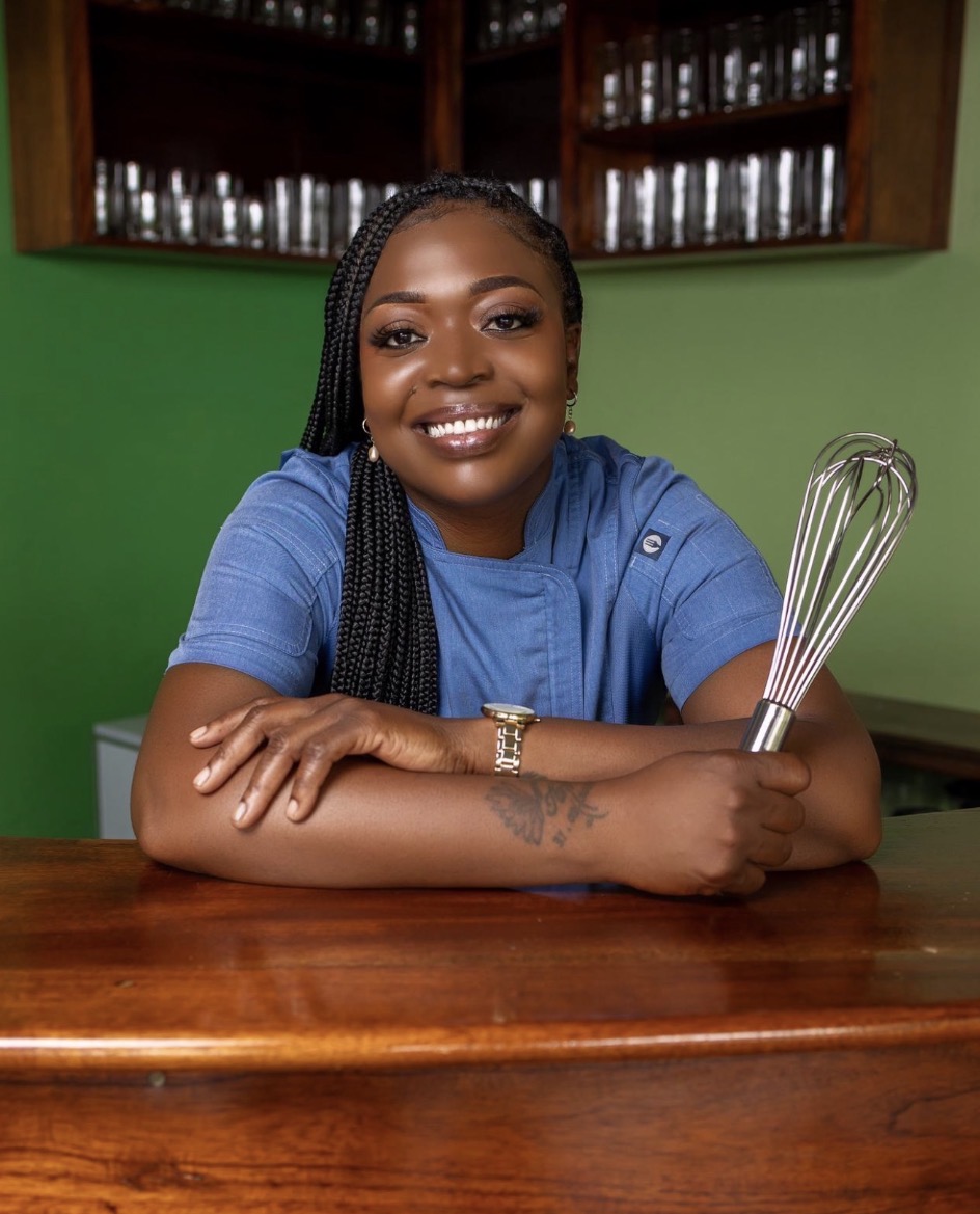 The founder of The Caribbean Kids Table Foundation in her kitchen, holding a whisk